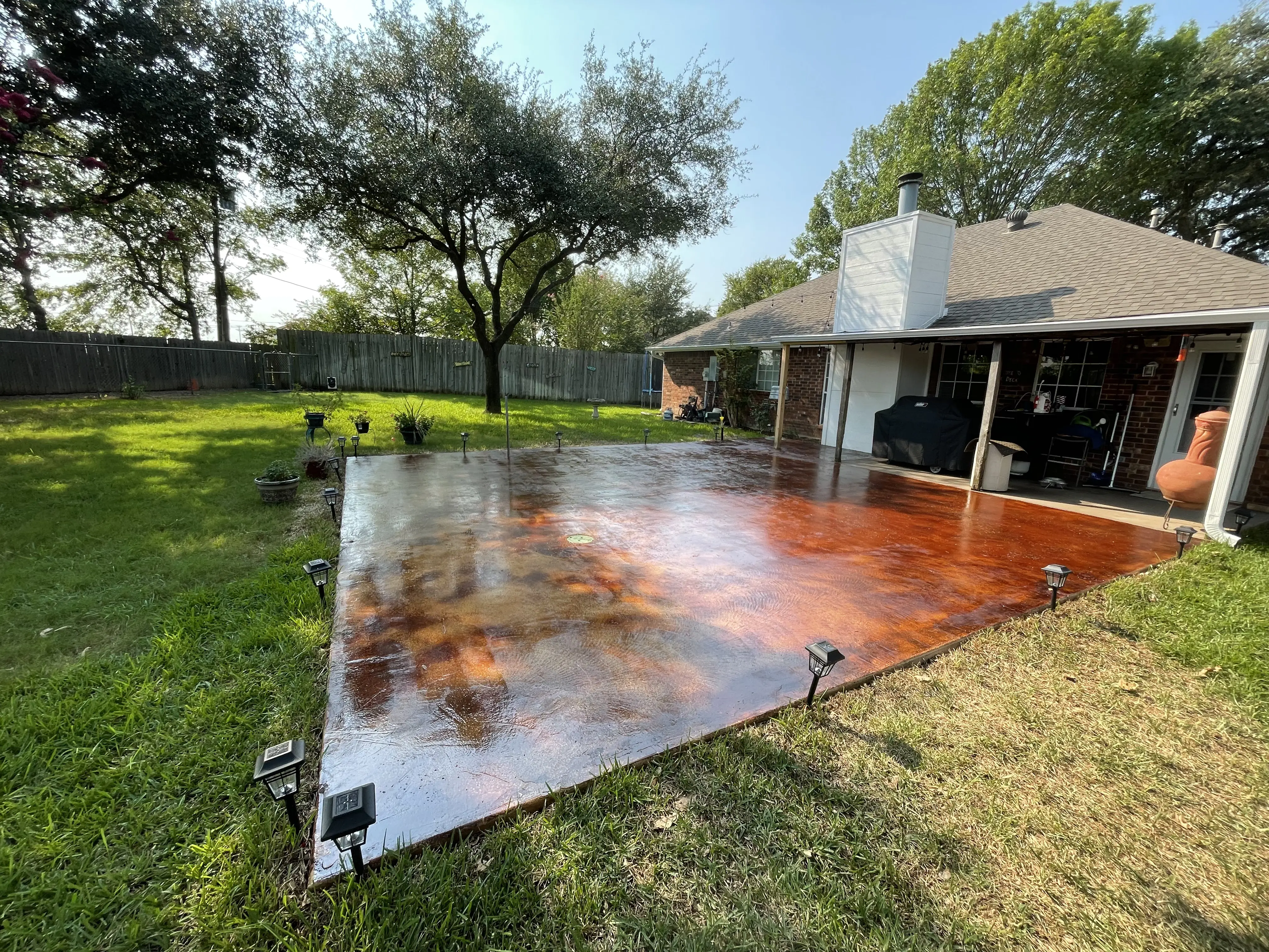 Beautiful reddish-brown acid-stained concrete patio with texture